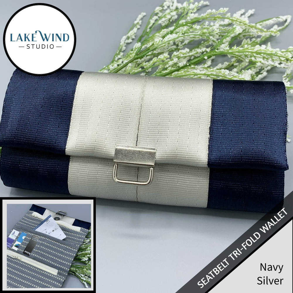 Navy and silver tri-fold wallet with a close-up inset on a gray background