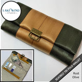 Tri-fold wallet in rust and olive green with 'Lake Wind Studio' branding.
