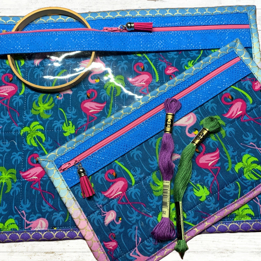 Embroidery hoop and thread on a blue fabric with flamingo pattern