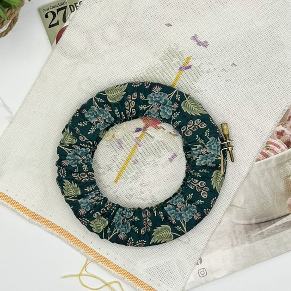 Embroidery hoop with floral design on a white fabric background