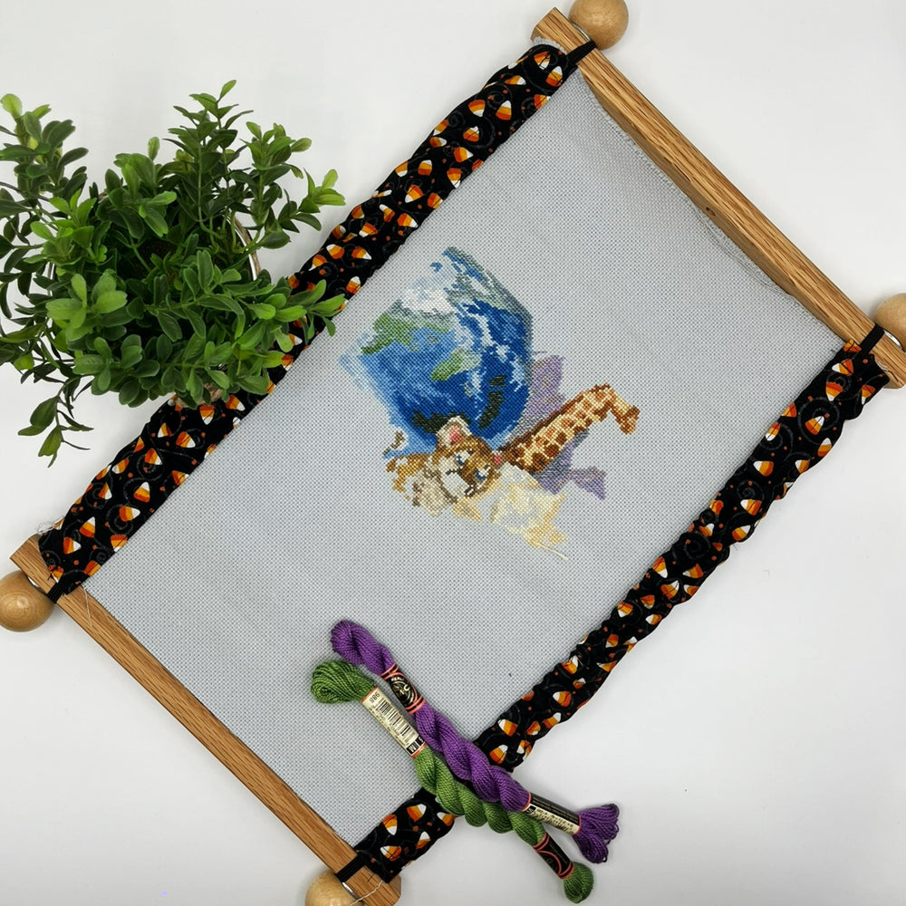 scroll frame grime guard with halloween candy corn on black fabric background