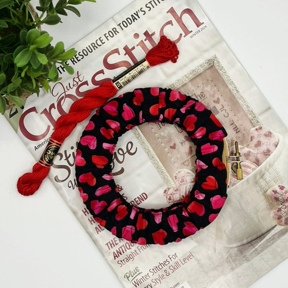 Embroidery hoop with  pink hearts on a Cross Stitch magazine
